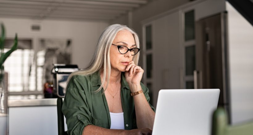 Worried senior woman using laptop